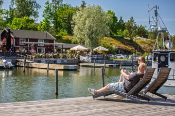 Tuoleissa istujat rannalla