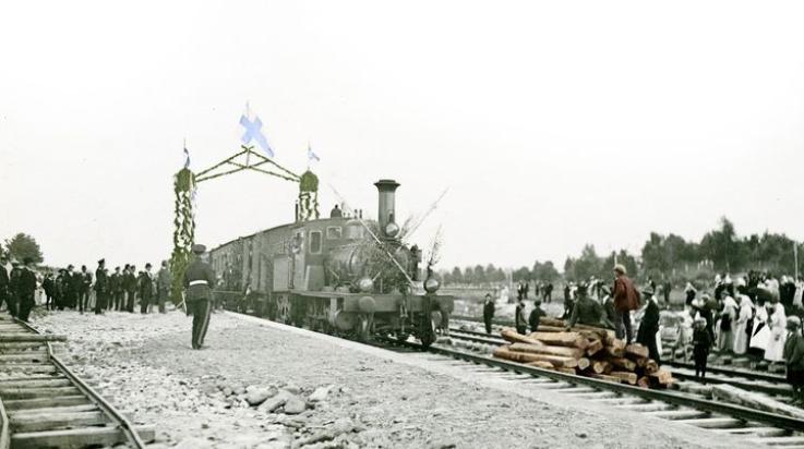 Vanha mustavalkoinen kuva höyryveturilla tomivasta junasta, joka saapuu Uuteenkaupunkiin.